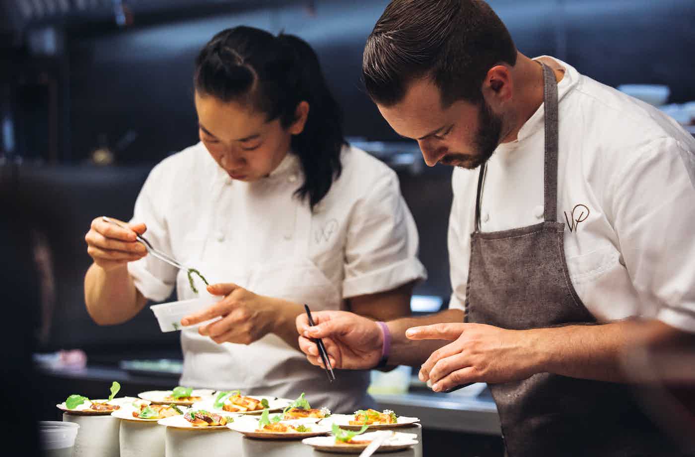 Two chefs plating dishes
